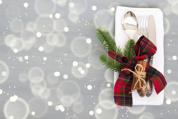 Festive table setting for Christmas dinner on a gray wooden background with place for text. The concept of winter holidays. Flat layout.