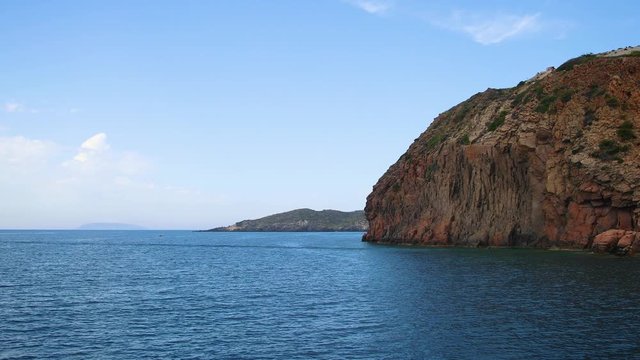 Stabilized shot of boat on island near Kos island. Rocks at Kos island in Greece. Blue water.