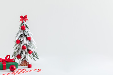 Obraz premium Christmas holiday composition. Xmas tree, decoration and gift on white background. Christmas, New Year, winter concept. Front view, copy space