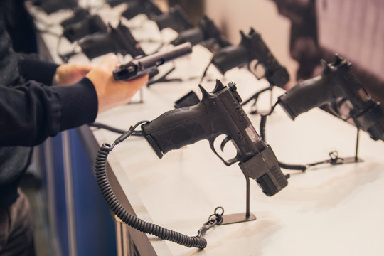 Gun In His Hand. Exhibition And Sale Of Weapons