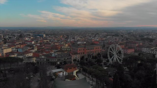 Drone on Italian city at sunset with panoramic wheel