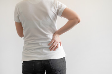 Obraz premium Close-up view of caucasian woman with pain in kidneys isolated on a white background. Girl with backache clasping her hand to her lower back. Woman suffering from ribbing pain.