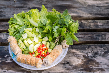 Vietnamese food with vegetables on wooden table.