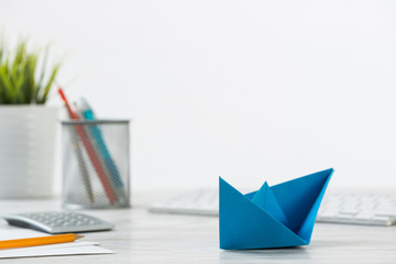 Wooden office desk with deep blue origami boat