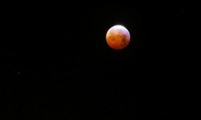 Moon eclipse in orange colours during nighttime in the nightsky © Kristoffer