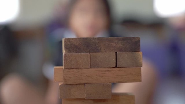 Closeup hand playing wooden block puzzle, Development or constructive concept in slow-motion