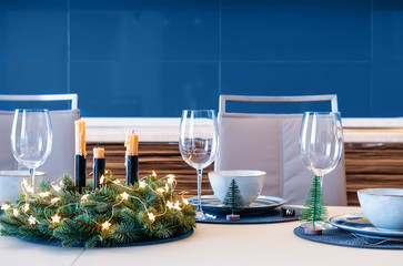 Christmas festive table decoration with spruce wreath. Classic blue color in modern interior