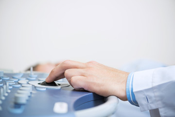 Sonographer using ultrasound machine at work.