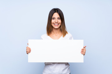 Young woman over isolated blue background holding an empty white placard for insert a concept