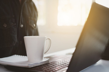 Men wearing denim shirts are working on laptops, on desks, in office spaces with windows. Freelance, find a job, do business with customers, concepts.