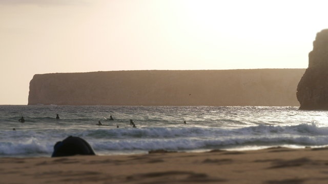 Sunset in Portugal at the atlantic ocean with sufers