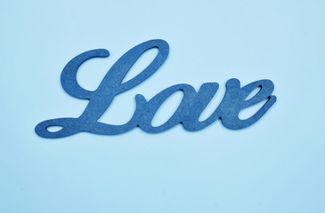 Wooden word Love on blue background.