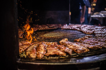 Fried meat, rib meaton a black background of charcoal. Cooked juicy ribs on charcoal. Fried ribs on charcoal.