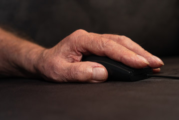 Hand von altem Menschen auf Computermaus