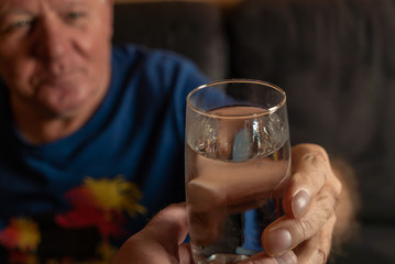 Senior bekommt ein Glas Wasser gereicht
