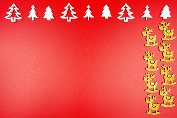 White wood Christmas trees arranged in a row at the top and golden reindeer on the right, isolated on a red background.