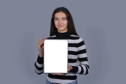 girl holding blank vertical canvas in hands empty frame mock-up poster