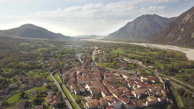 Top down aerial view of a small historic town Venzone in Northern Italy with red tiled roofs of old buildings.