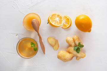 Tea with ginger, mint, lemon and honey on a white wooden table. Top view
