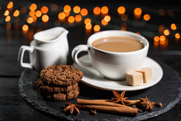 A cup of coffee against the backdrop of the Christmas background. Cookies, spices.
