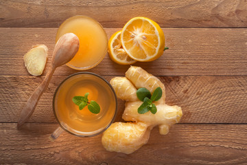 Ginger tea with lemon, honey and mint on a wooden table. Top view