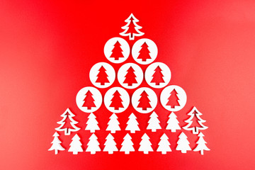 Naklejka na ściany i meble Wooden Christmas tree of white wood arranged in the shape of a large Christmas tree, isolated on a red background.