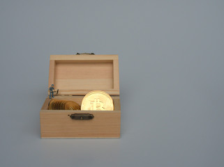 Miniature people as worker are working on the Bitcoin Crypto currency that is stored in the wooden box.