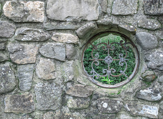 old stone wall with a round window
