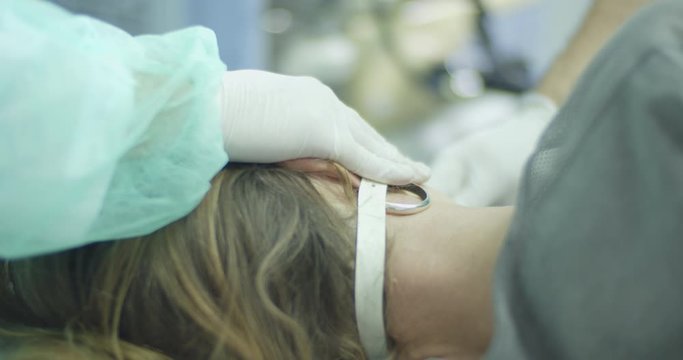 Female patient lying on bed during endoscopy procedure in office room.
