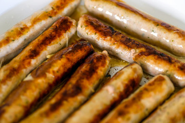 fried german bockwurst sausage in a pan. closeup view