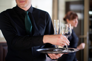 Waiter carrying glasses of wine on a tray