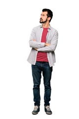 Full-length shot of Handsome man with beard with confuse face expression over isolated white background