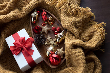 Cozy rustic Christmas background on a wooden background with a gift and Christmas decor items in a homely atmosphere.Top view, flat lay.Holidays, New Year 2020 present concept.