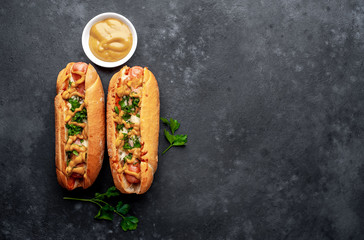 french hot dogs baked with cheese and mustard on a stone background with copy space