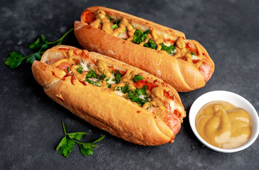 french hot dogs baked with cheese and mustard on a stone background