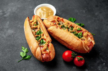 french hot dogs baked with cheese and mustard on a stone background with copy space