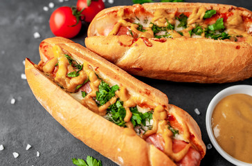 french hot dogs baked with cheese and mustard on a stone background