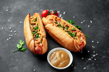 french hot dogs baked with cheese and mustard on a stone background