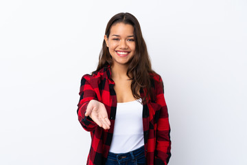 Young Colombian girl over isolated white background handshaking after good deal