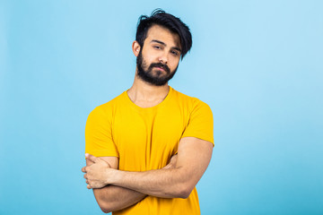 Fototapeta premium Emotional portrait of a Hindu man in a yellow T-shirt on a bright blue background