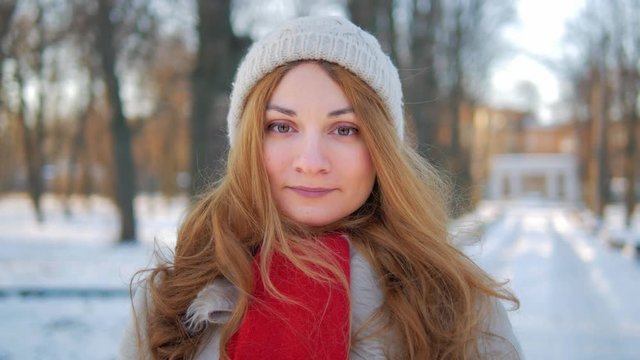 portrait of cheerful young woman in winter park