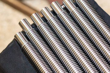 The spare parts of the lead ball screw for CNC milling machine in the light blue scene. The CNC machine parts manufacturing process.