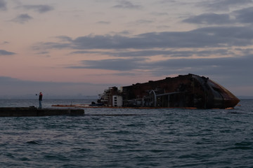 A sunken tanker off the coast of Odessa. Overcast dawn.