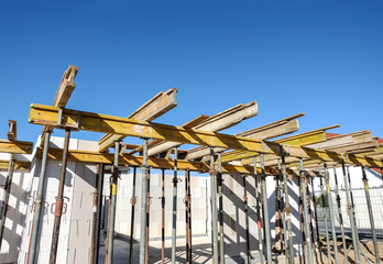 Baustelle mit Blick in den Rohbau eines Hauses und Deckenstützen – viel blauer Himmel für...