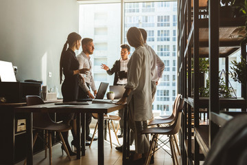 A team of young businessmen working and communicating together in an office. Corporate businessteam and manager in a meeting.