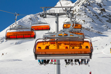Panorama of ski resort in Soelden, Tirol, Austria. Bright orange ski carriage and skiers. Alps...
