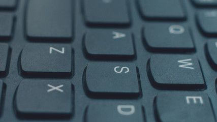 Modern black laptop keyboard closeup, english alphabet.