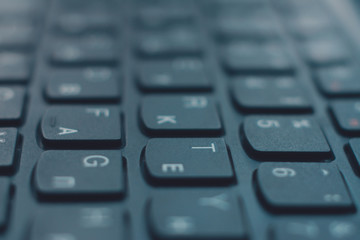 Closeup black keyboard with Ukrainian and English alphabet layout.