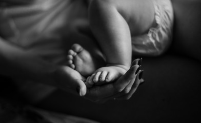 Mom’s hands are holding baby’s legs