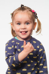 A very nice little girl shows her tongue.